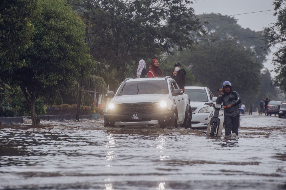 Motorists attempt to drive through floodwaters in Kampung Jalan Kebung in Shah Alam December 18, 2021. u00e2u20acu2022 Picture by Shafwan Zaidon