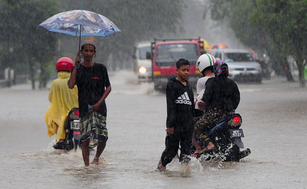 People wade through floodwaters in Kampung Jalan Kebung in Shah Alam December 18, 2021. u00e2u20acu2022 Bernama pic