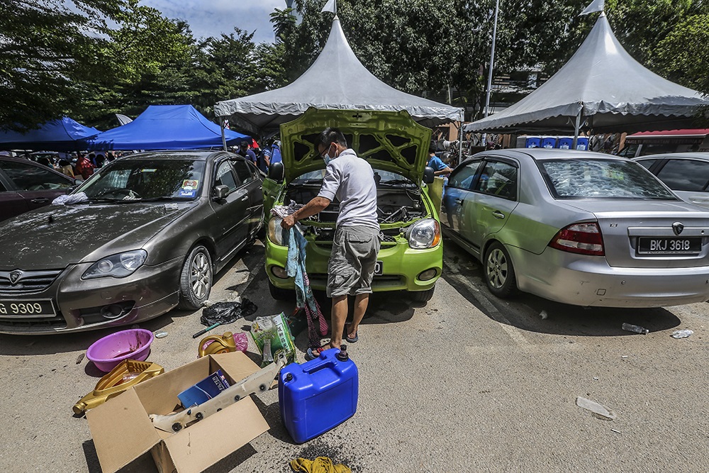 Flood victims are seen repairing their cars after a heavy flood in Taman Sri Muda in Shah Alam, Selangor December 21, 2021. u00e2u20acu201d Picture by Hari Anggara