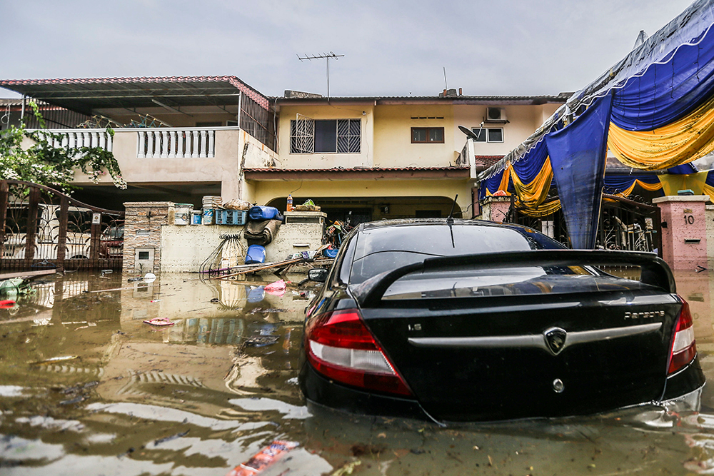 雪州莎阿南太子园（Taman Sri Muda）的住家严重淹水，民众的车辆也浸泡在水中动弹不得。-Hari Anggara摄-