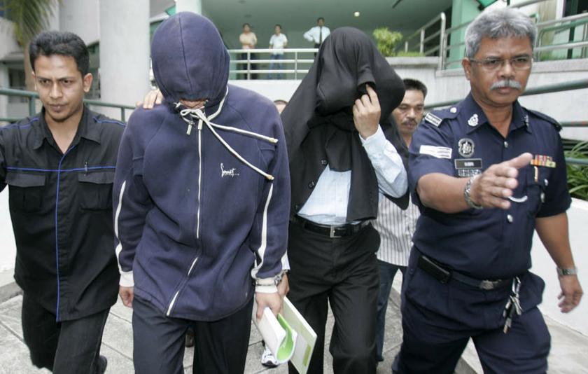 File photo of ex-policemen Azilah Hadri and Sirul Azhar Umar (heads covered). The Court of Appeal in Putrajaya on August 23, 2013 overturned their conviction of murdering Mongolian model Altantuya Shaariibuu. u00e2u20acu201d Reuters pic