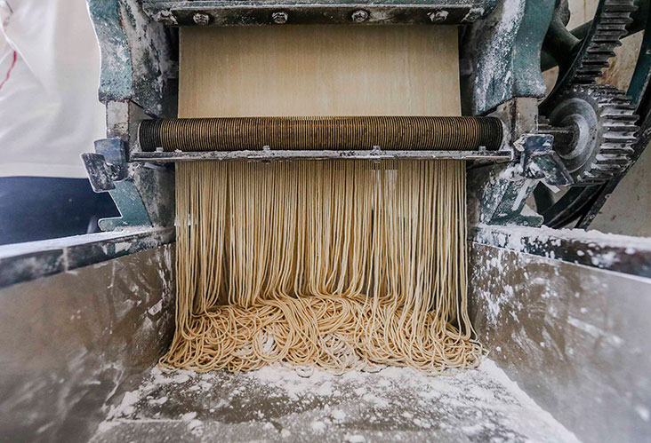 面皮再放进切割机面条就出来了。-Firdaus Latif摄-