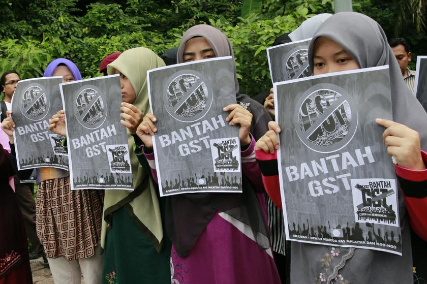 Participants of an anti-GST rally holding banners in front of Parliament before the tabling of Budget 2014 in Kuala Lumpur October 25, 2013. u00e2u20acu201d Picture by Saw Siow Feng
