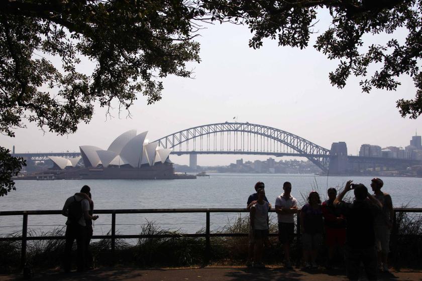 Tourists take photographs as they stand in front of the Sydney Opera House and Harbour Bridge on a hazy day October 21, 2013. u00e2u20acu201d Reuters pic