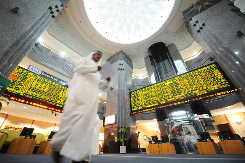 An investor walks past electronic boards displaying stock information at the ADX Abu Dhabi Securities Exchange stock market in this May 16, 2012 file photo. u00e2u20acu201d Reuters pic