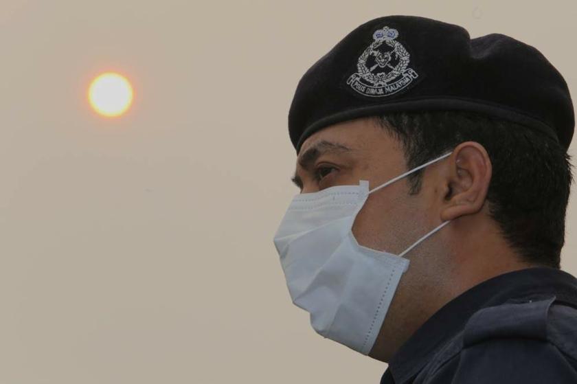 A policeman wears a mask for protection against the haze while on duty in Kuala Lumpur on June 24, 2013. u00e2u20acu201d Picture by Choo Choy May