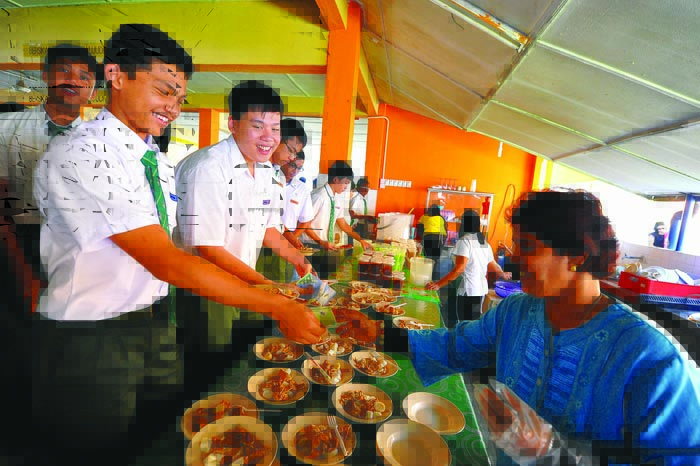 Schoolboys buy chee chong fun costing RM2.50 a bowl from their school canteen.