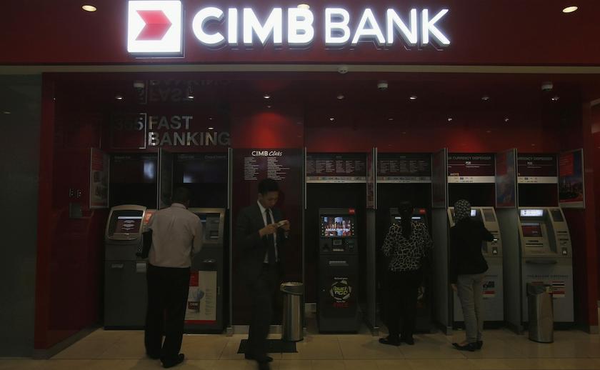 Customers use cash machines at a branch of Malaysiau00e2u20acu2122s CIMB Bank in Kuala Lumpur, in this February 7, 2013 file photo. u00e2u20acu201d Reuters pic
