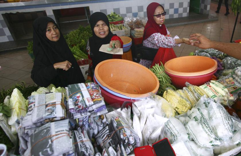 Women pay their bills at a wet market in Shah Alam outside Kuala Lumpur January 22, 2014. Malaysiau00e2u20acu2122s inflation rate jumped in December, exacerbating a political headache for the government over rising living costs. u00e2u20acu201d Reuters pic