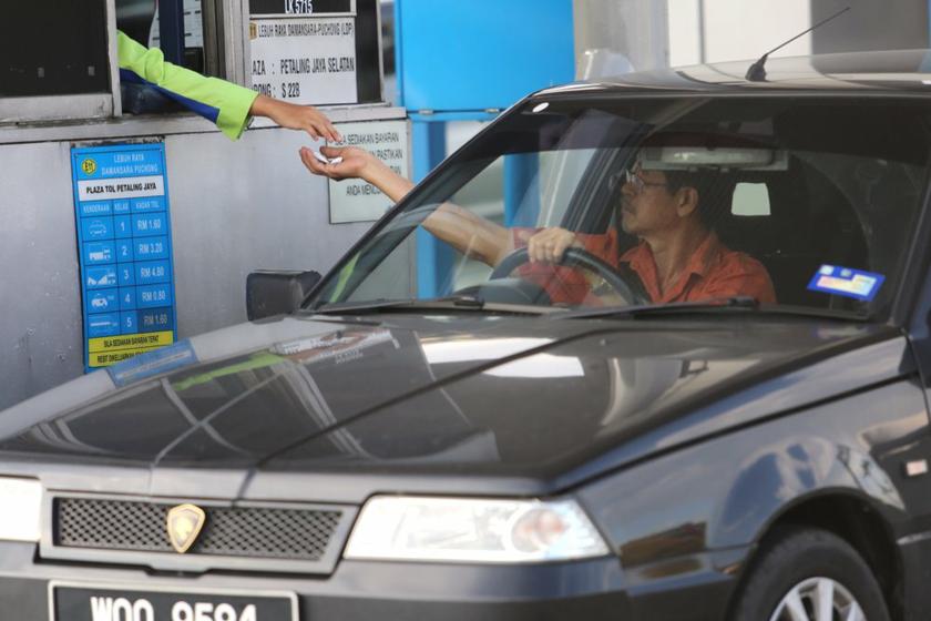 A Malaysian highway user pays a toll station in Kuala Lumpur December 18, 2013. u00e2u20acu201d Picture by Choo Choy May