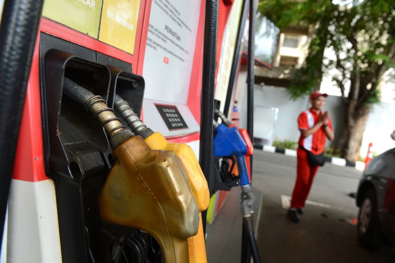 An attendant attends to a customer at a Pertamina fuel station, a state-owned petroleum company in Jakarta on June 18, 2013. u00e2u20acu201d AFP