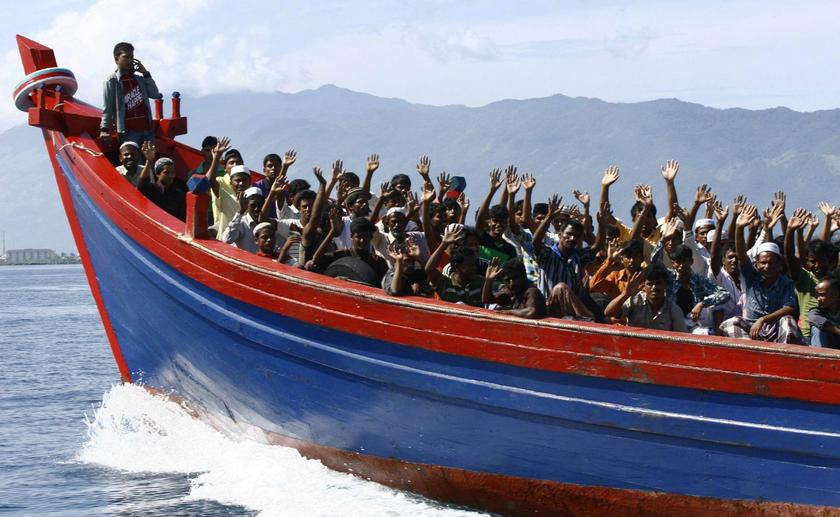 Ethnic Rohingya refugees from Myanmar wave as they are transported by a wooden boat to a temporary shelter in Krueng Raya in Aceh Besar in this April 8, 2013 file photo. 