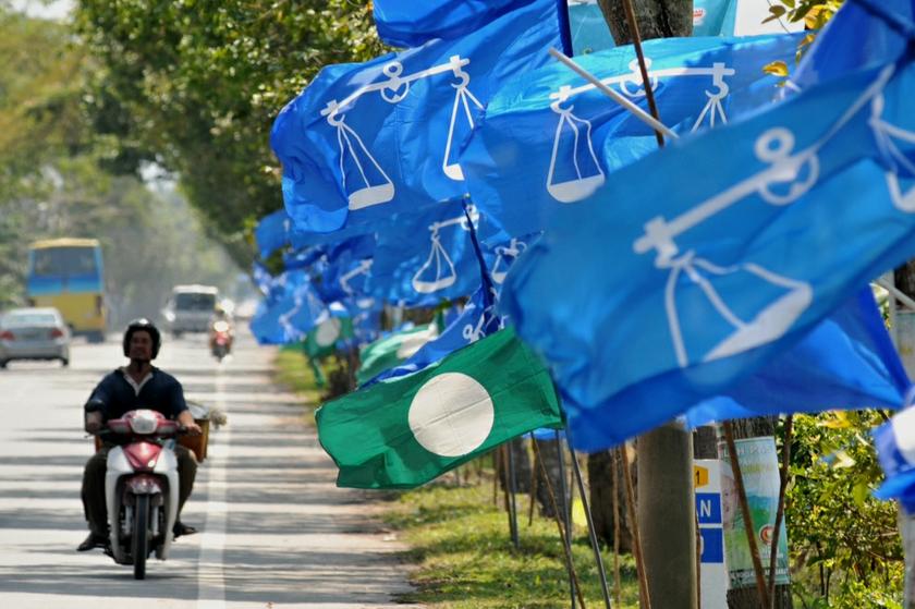 Motorist passing by row of Barisan Nasional and PAS flags during the run up to the Sungai Limau by-election at Sungai Kering in Sungai Limau, Kedah, October 31, 2013. u00e2u20acu201d Picture by K.E. Ooi