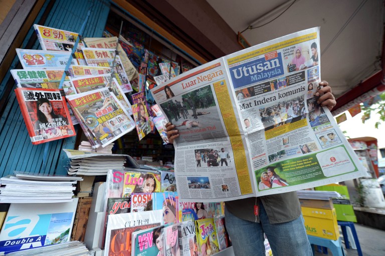 A Malaysian man reads a newspaper outside a shop in downtown Kuala Lumpur on October 10, 2012. u00e2u20acu201d AFP pic